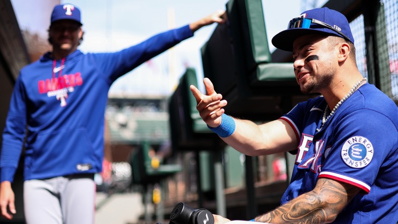 Two baseball players sitting in the dugout during a baseball game