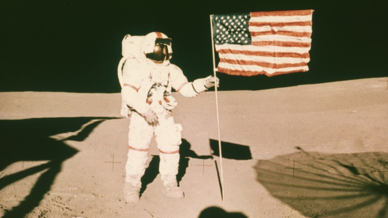 Astronaut Alan Shepard standing by the American flag on the moon during the Apollo 14 mission