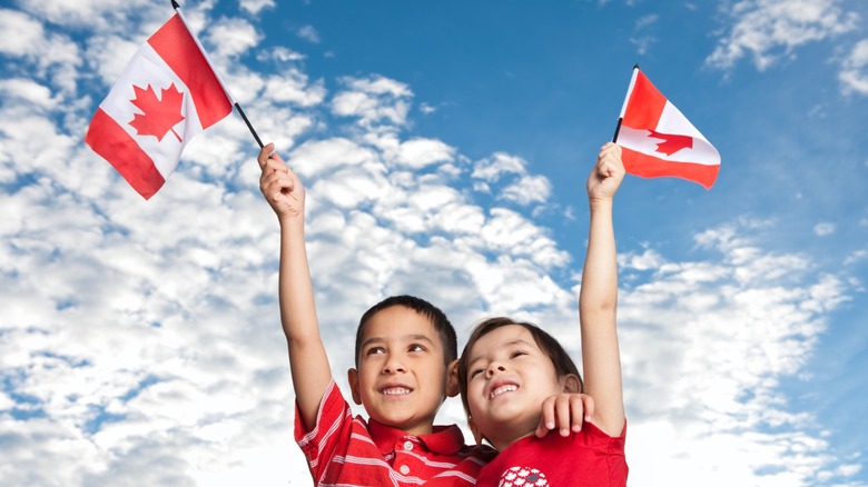 Two children holding Canadian flags