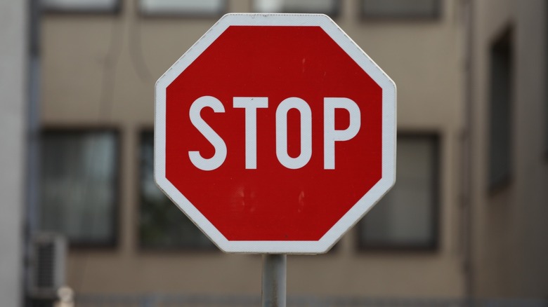 A stop sign with a building behind