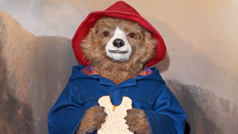A Paddington Bear statue eating a sandwich