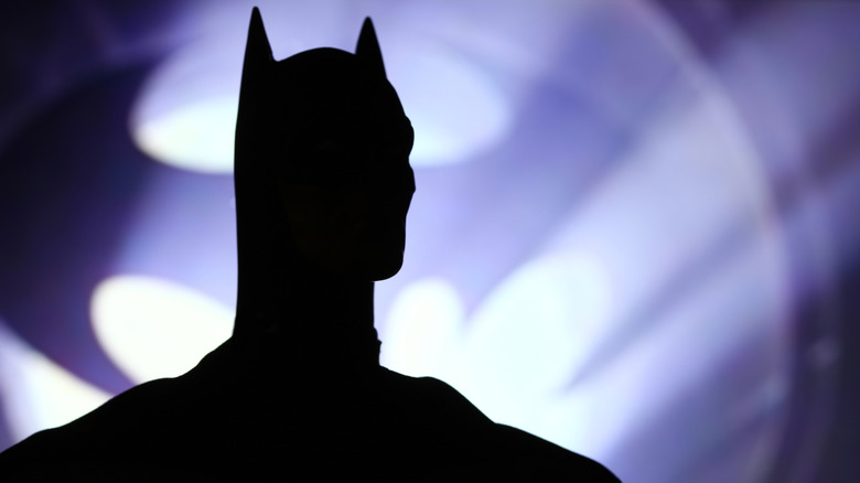 A person dressed as Batman standing outside a building