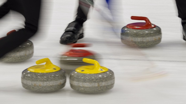 A group of people playing a game of curling