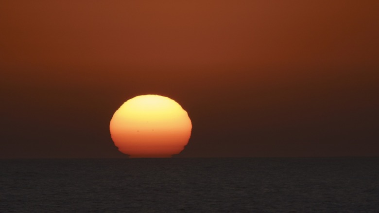 The sun over water during sunset
