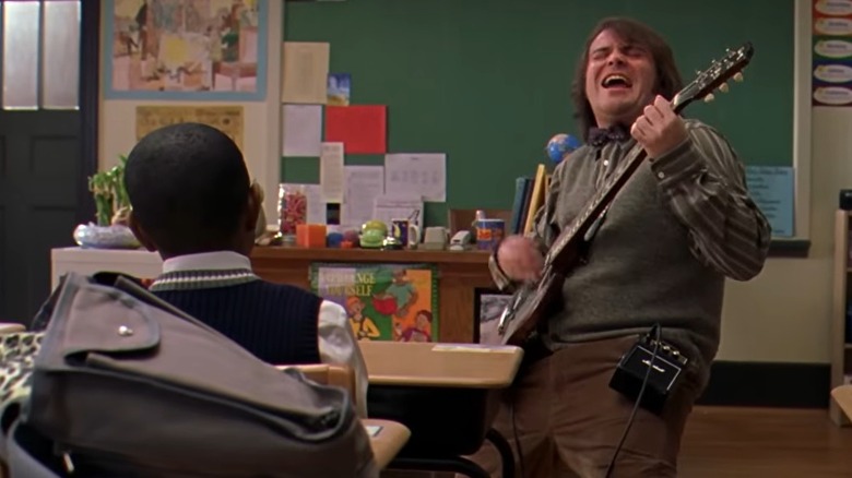 Jack Black with a guitar in a classroom in the School of Rock trailer