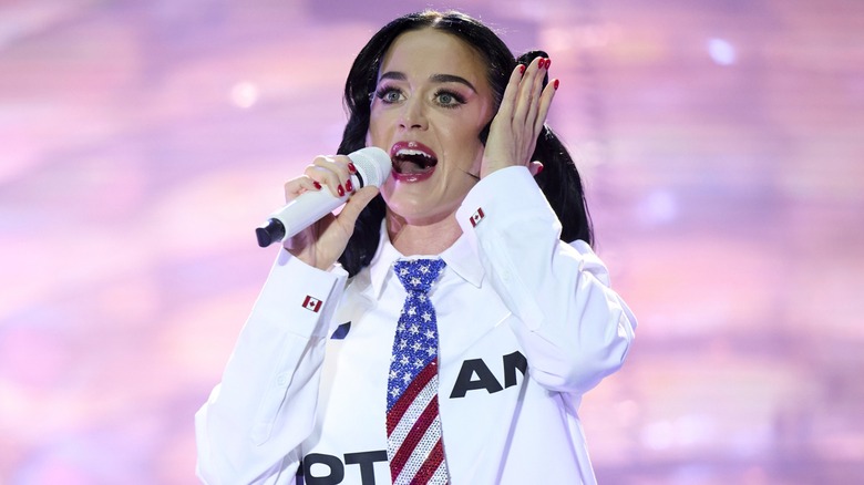 Katy Perry performing on stage wearing a bedazzled American flag tie