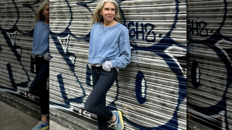 woman leans against wall