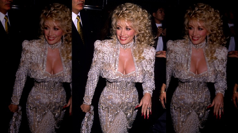 Dolly Parton on the red carpet in a bejeweled white gown