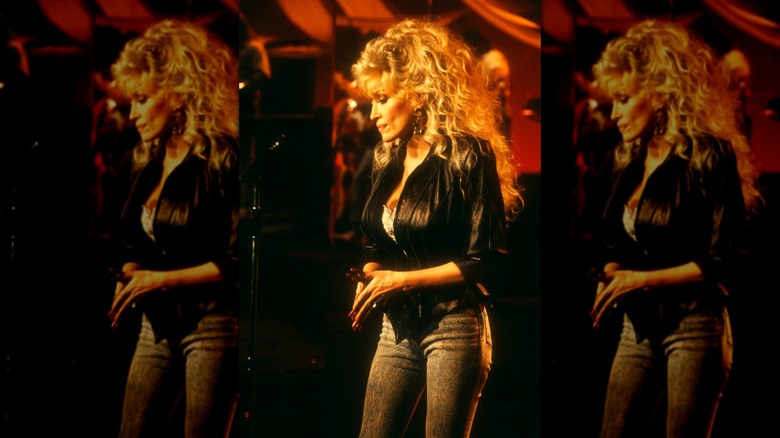 Dolly Parton performing in a leather jacket and jeans