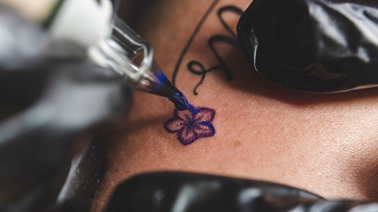 Person getting small floral tattoo
