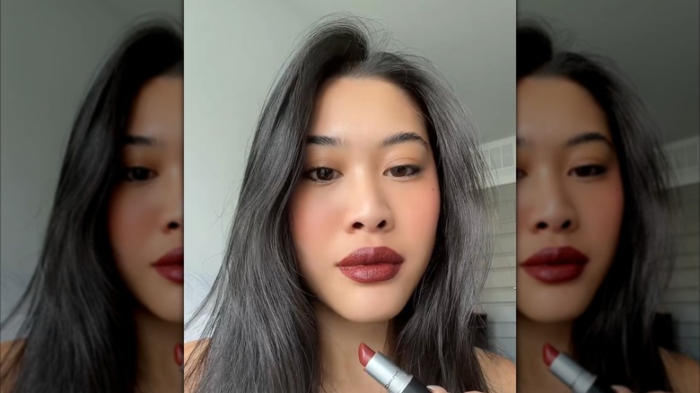 A woman with matte burgundy red lipstick