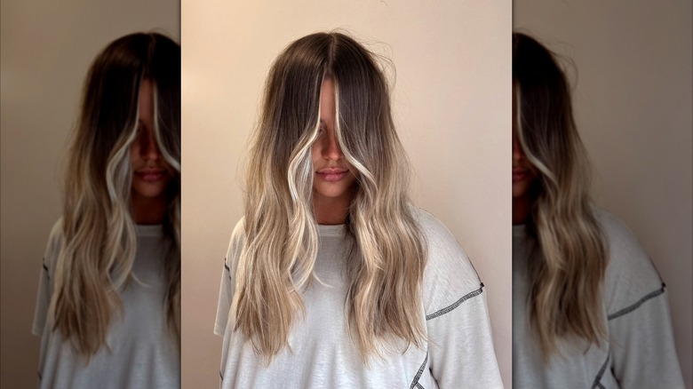 A woman with ombre blonde hair falling in front of her face