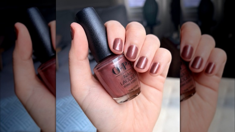 A picture of a woman holding the OPI nail polish Root Beer Float on Instagram