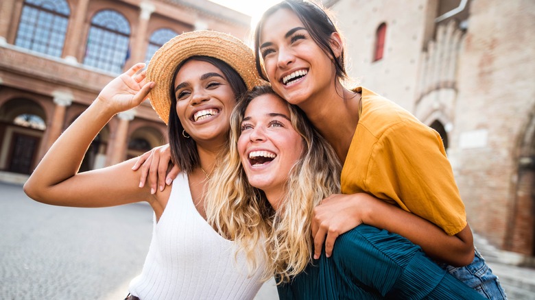 three woman smiling outside