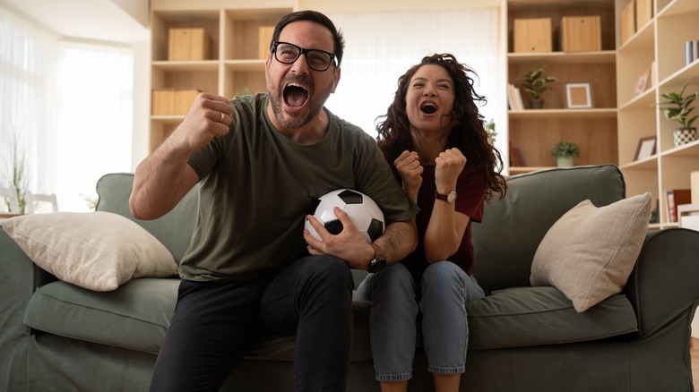 A couple watching a soccer match from their couch