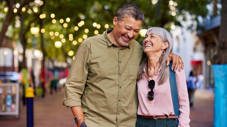 An older couple smiling while out on a stroll