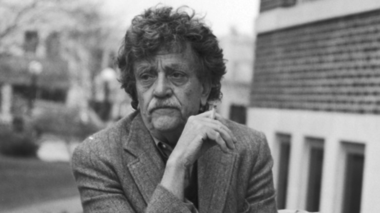 A black and white photo of Kurt Vonnegut Jr. smoking a cigarette outside