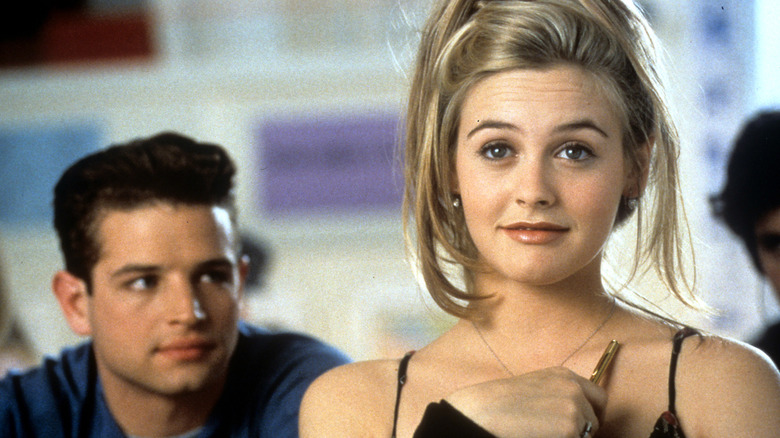 A still from the movie "Clueless' featuring Cher with Christian looking at her from behind