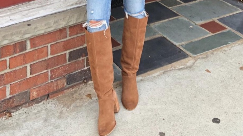 A woman wearing brown suede boots