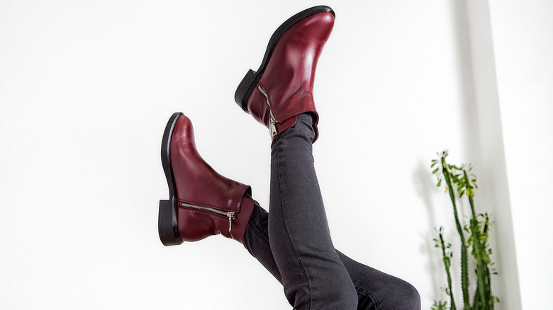 A pair of dark red boots kicked in the air