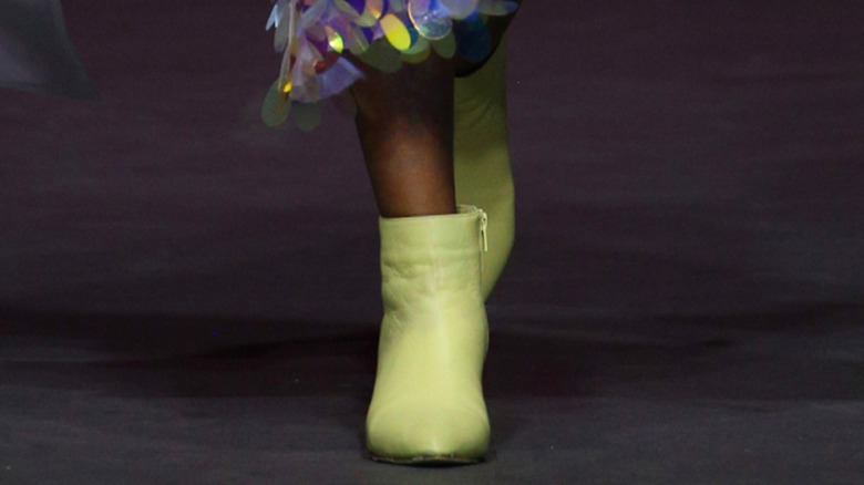 A woman wearing light green boots