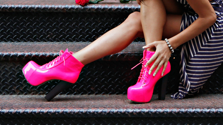 A woman wearing hot pink Jeffrey Campbell Lita boots