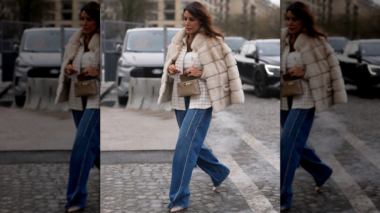 A woman wearing denim and a fur coat