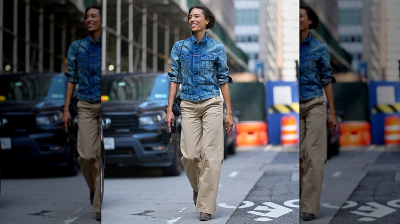 A woman wearing a fitted jacket and tan trousers