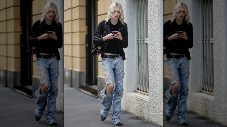 A woman wearing distressed jeans and a leather jacket in Paris