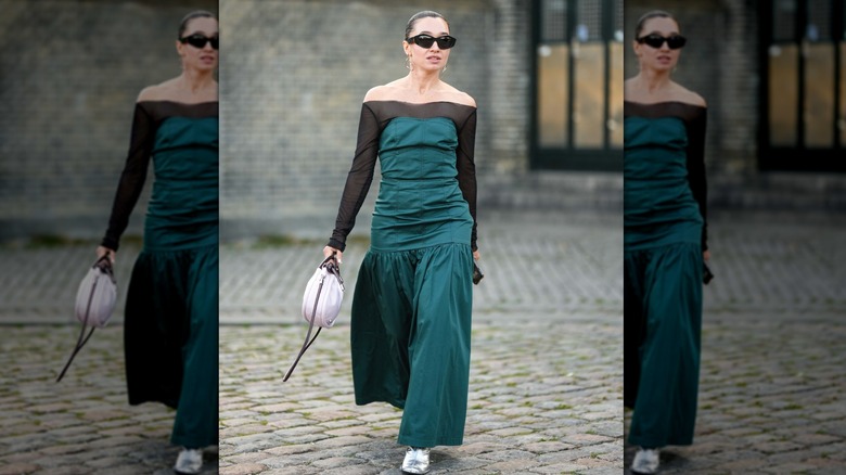 Woman wearing a black and green drop waist dress