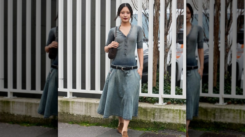 Woman wearing a denim midi, drop-waist skirt