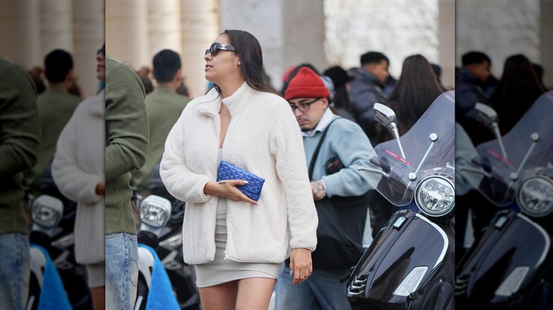 Woman wearing white furry coat and mini dress