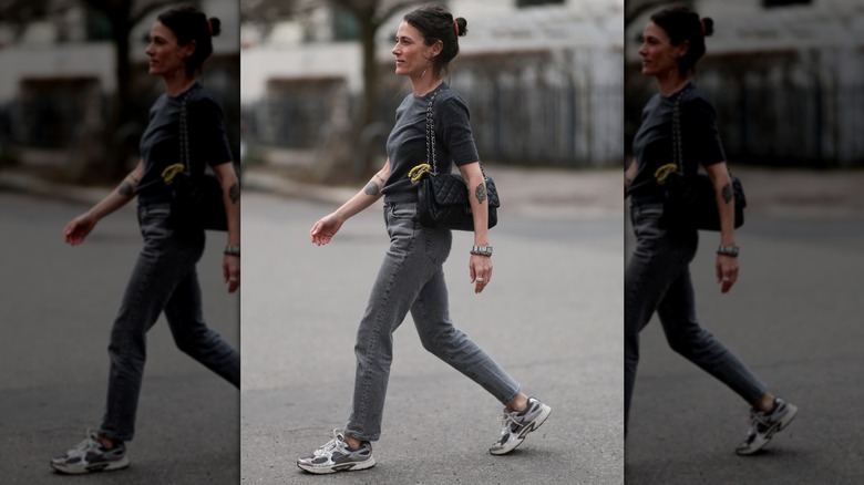 A woman wearing gray skinny jeans with a black t-shirt