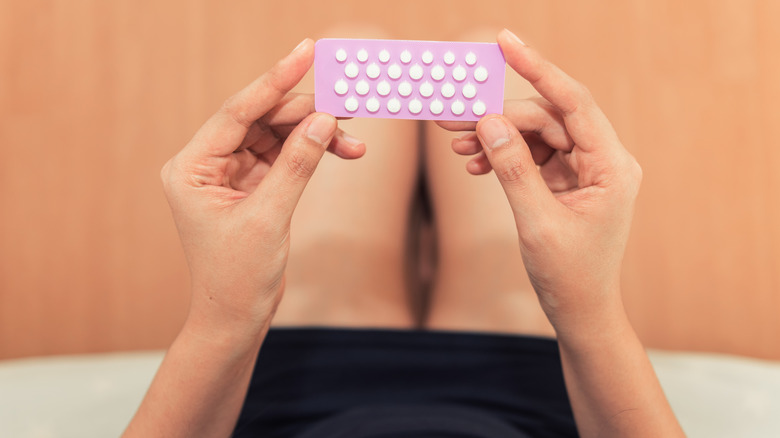 Woman holding the contraceptive pill