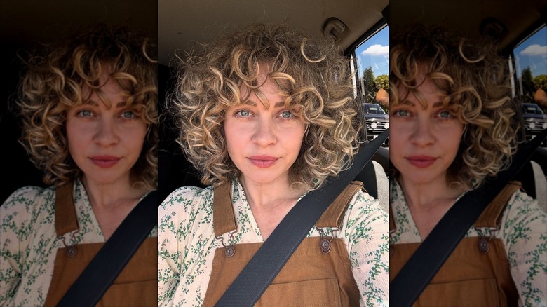 A woman with a rounded haircut and curly bangs