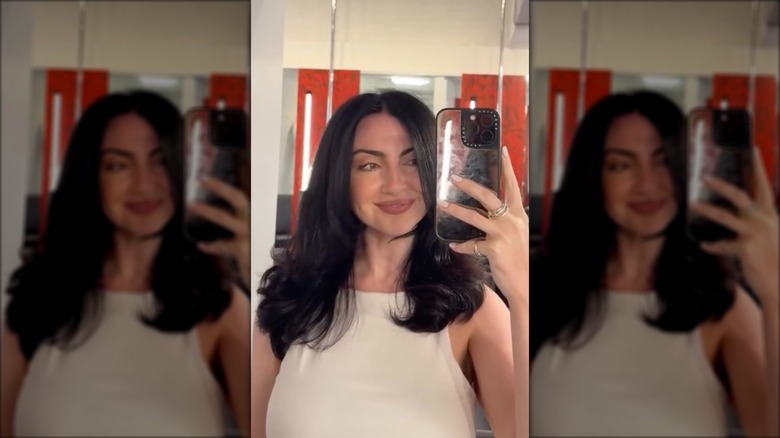 A woman with a medium length haircut and a middle part