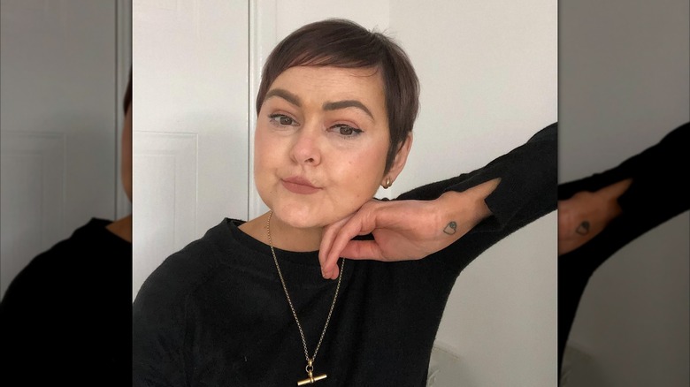 A woman with a pixie cut with sideswept bangs