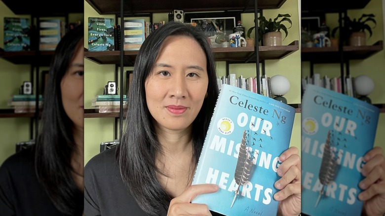 Celeste Ng holding a copy of her novel "Our Missing Hearts"