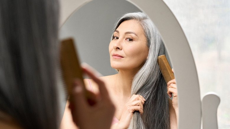 An older woman brushing her hair
