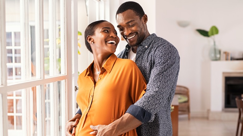Couple expecting a child, hugging and smiling