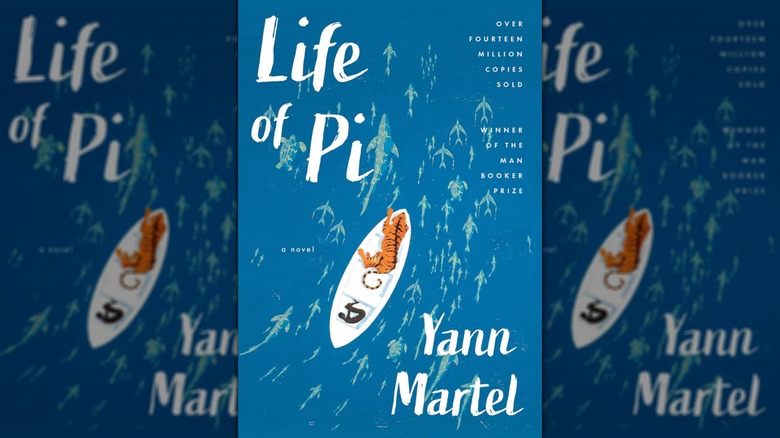 The cover of Life of Pi featuring a blue ocean and a boy in a boat with a tiger
