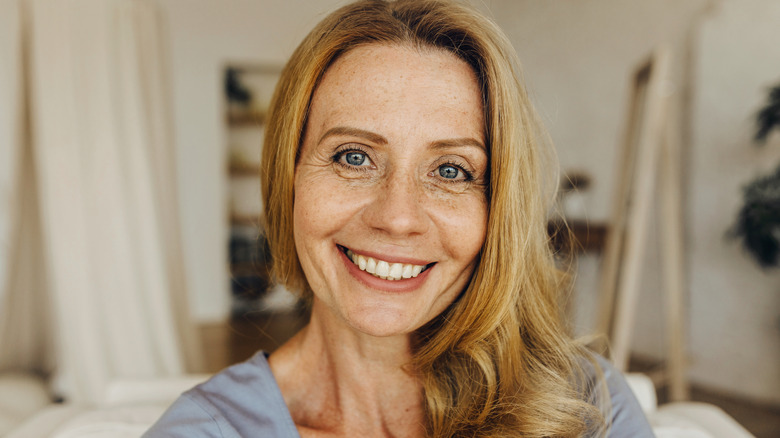 A pretty, blonde older woman with long hair smiling at the camera