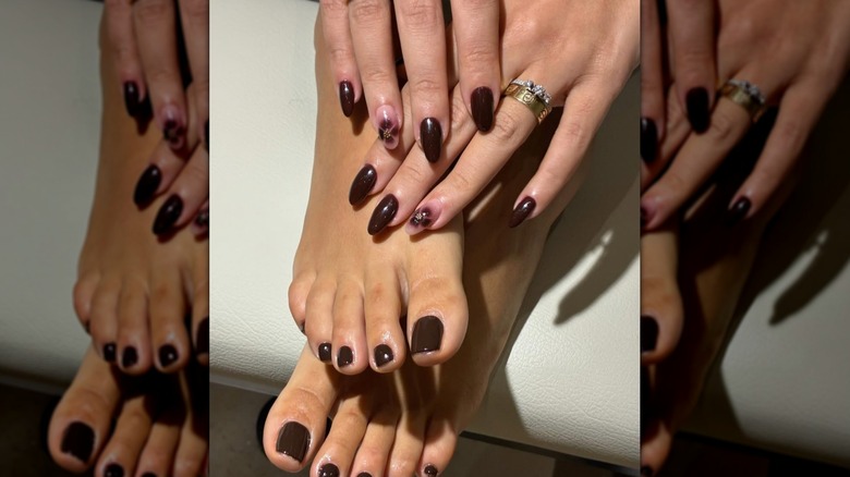 Hands and feet showing a matching manicure and pedicure in a dark brown color