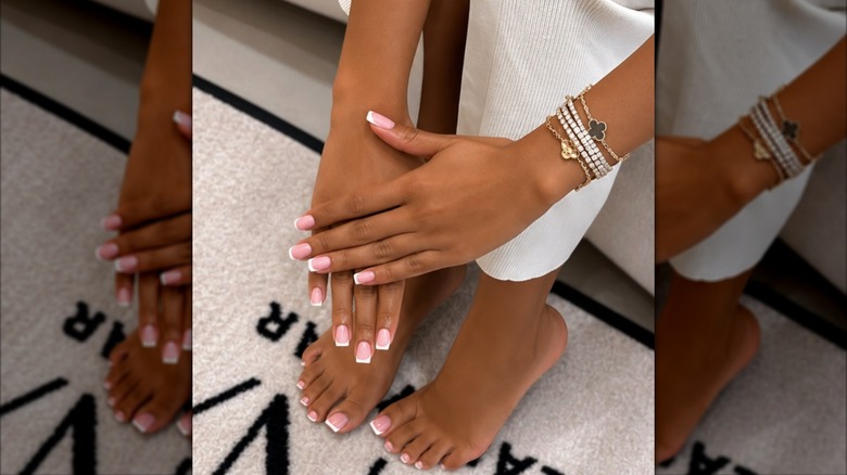 A woman with French tips on her fingers and toes