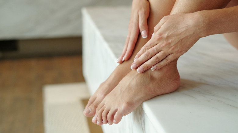 An image of a woman holding her hands and feet together