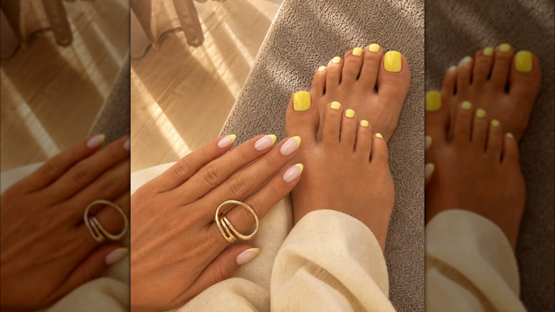 A woman with yellow French tips and a yellow pedicure