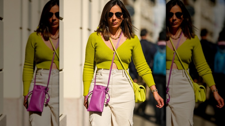 Woman in cropped lime green sweater and two cross-body bags