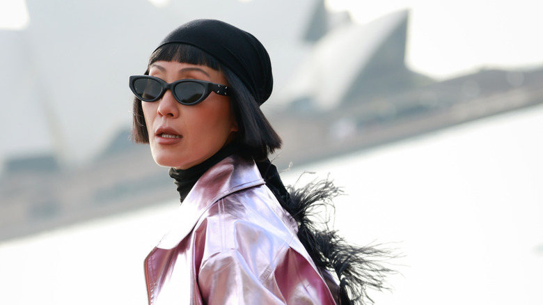Charlene Davies wearing black headscarf, black top, metallic pink leather zip up Gary Bigeni jacket, matching pants, black heels and black bag at Australian Fashion Week 2026 at Museum of Contemporary Art on May 15, 2026