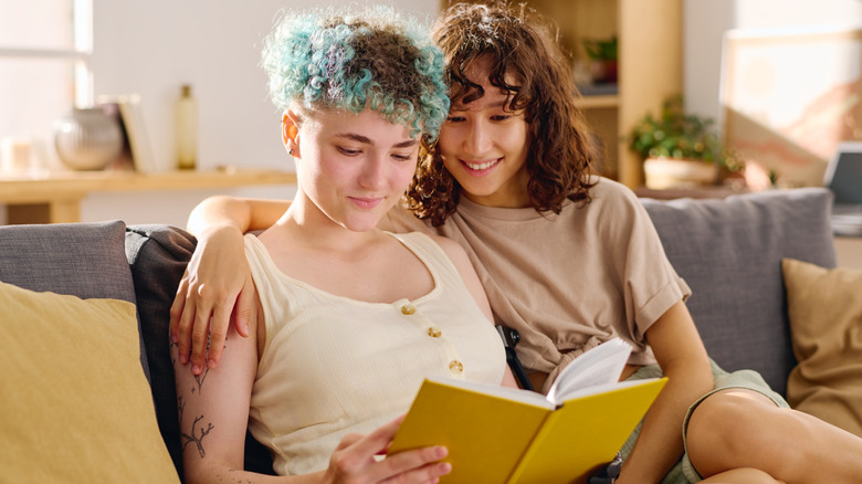 Two women reading a book together