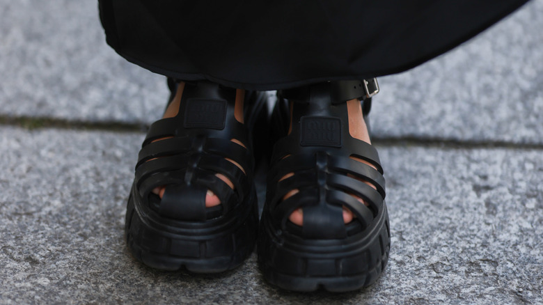 Close-up of platform fisherman sandals worn on a paved path